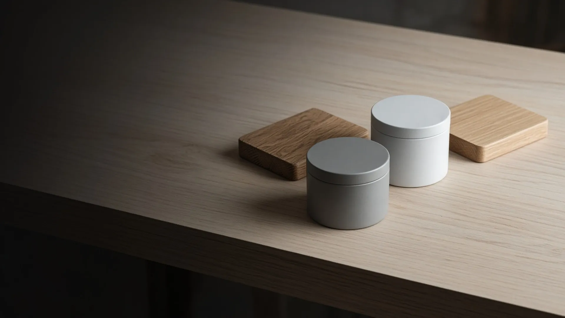 Two closed unlabeled tins beside two finished wood sample boards on a workbench