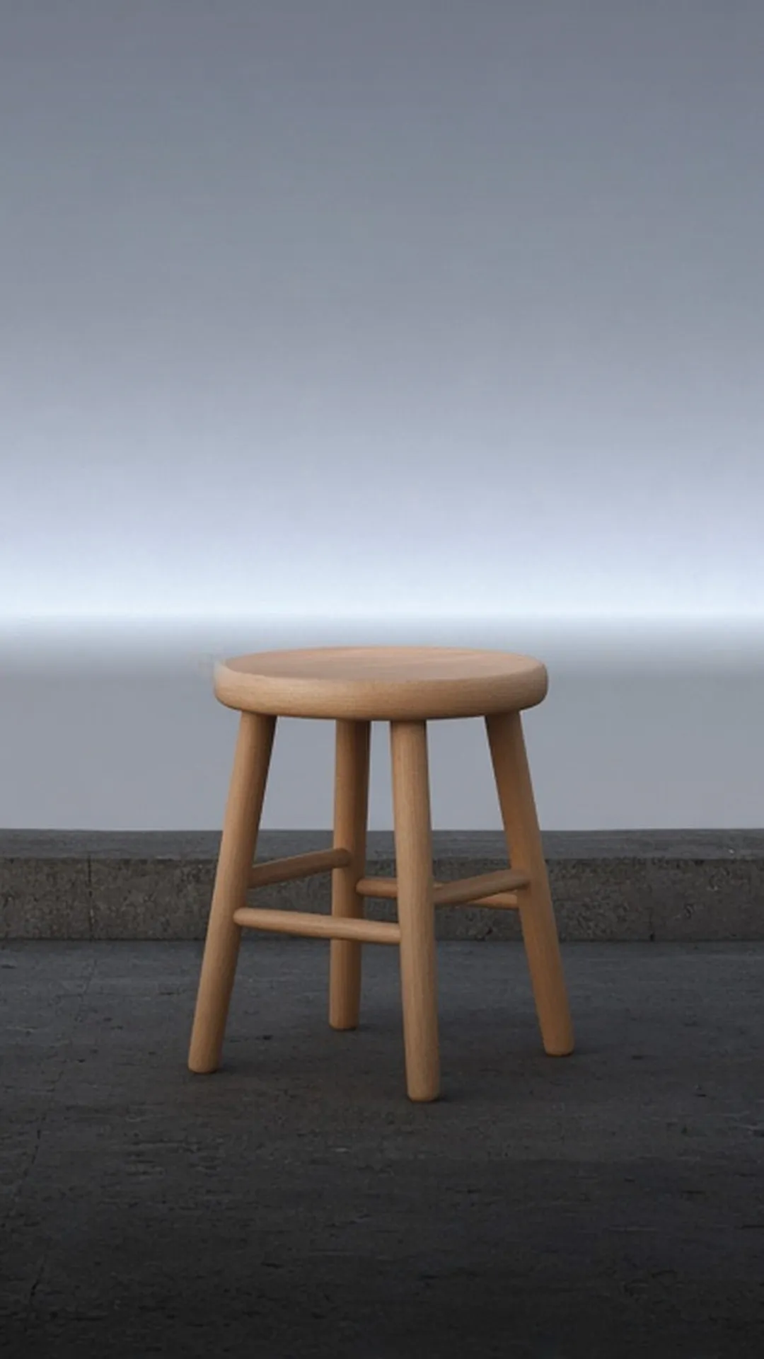 A smooth wood stool with a soft sheen standing on concrete before a plain grey wall