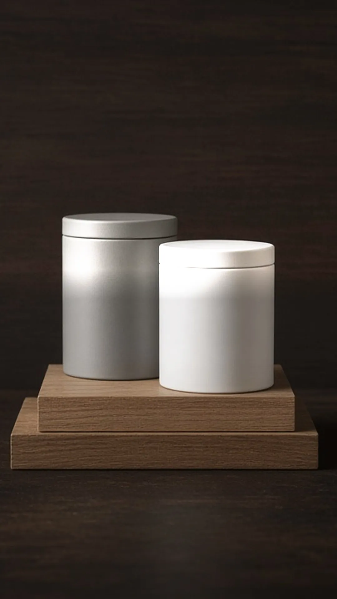 Two closed unlabeled tins, grey and white, on two stacked wood sample boards