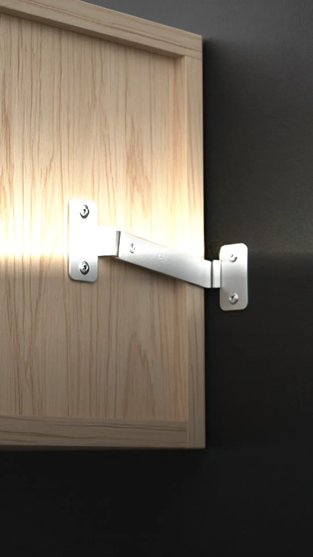 A plain metal bracket and strap joining the back of a dresser to a wall